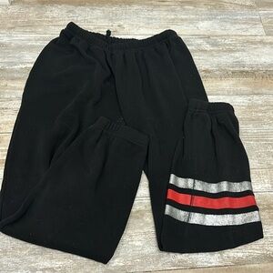 Black soft sweatpants with silver red stripe on bottom of left leg